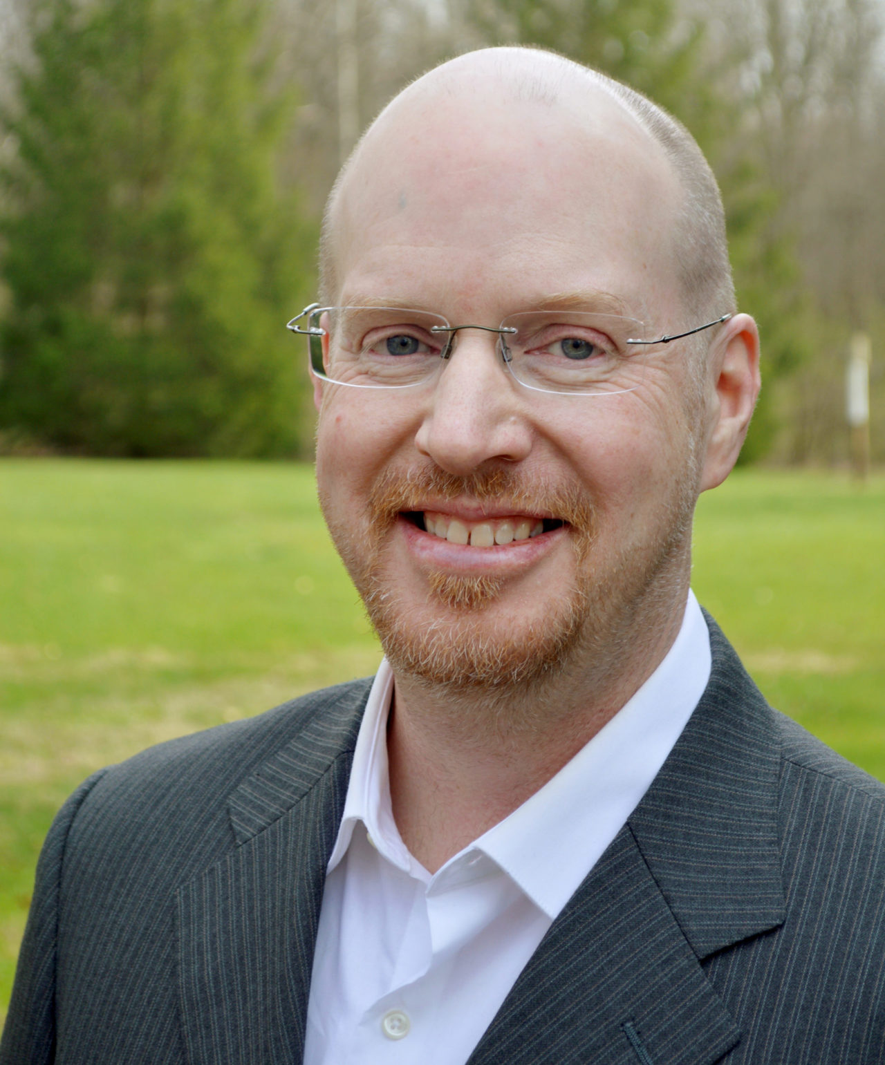 Mike Sherrill in front of a green landscape.