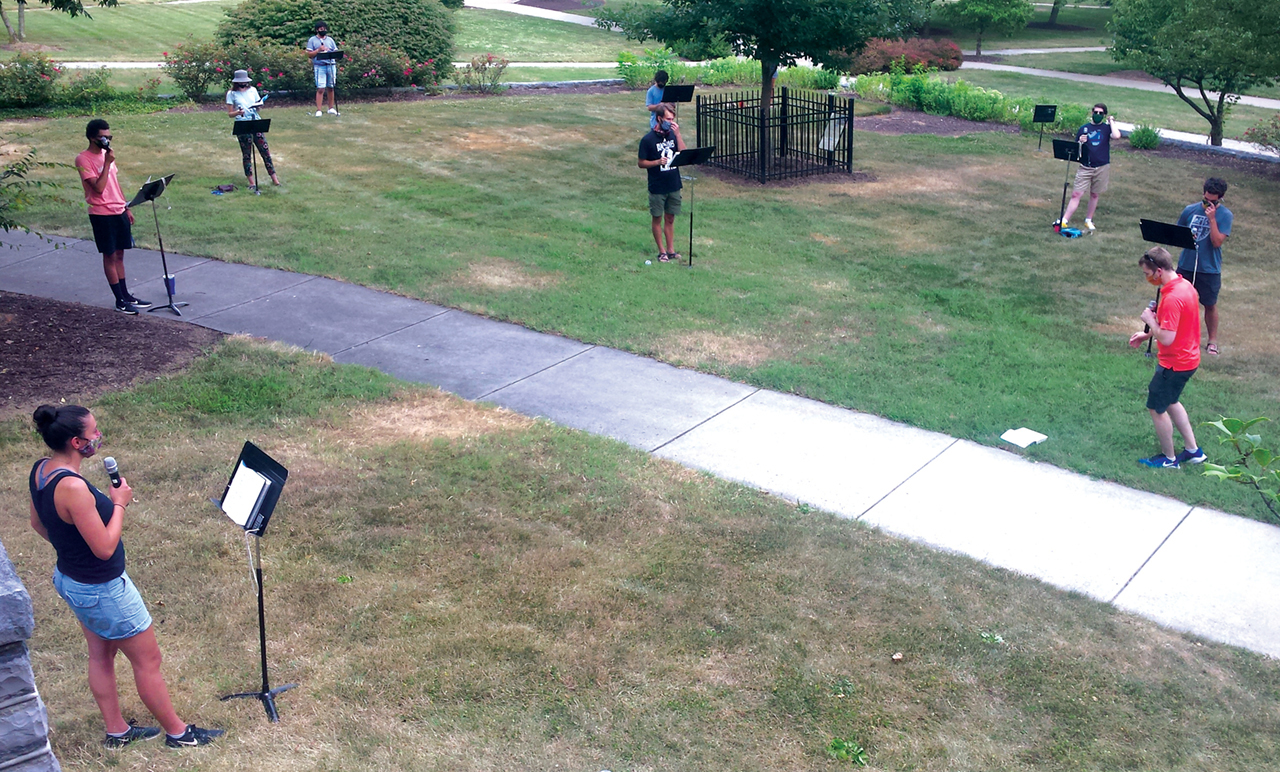 Eastern Mennonite University music professor Ben Bergey, right, and a group of student volunteers test equipment for choral practice in front of Lehman Auditorium. The singers wore masks, were positioned 12 feet apart, and used wireless microphones.