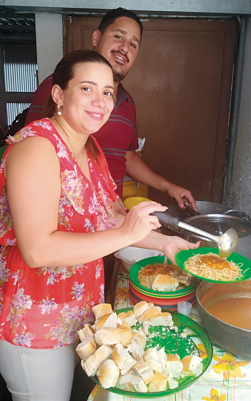 Helena Mirabal and Victor Mendez serve food for everyone after a service at the Mennonite church in the El Paraíso neighborhood of Caracas in Vene­zuela. The church also shares food with the broader community, especially people who are most vulnerable. — Juvenal Pacheco/MMN