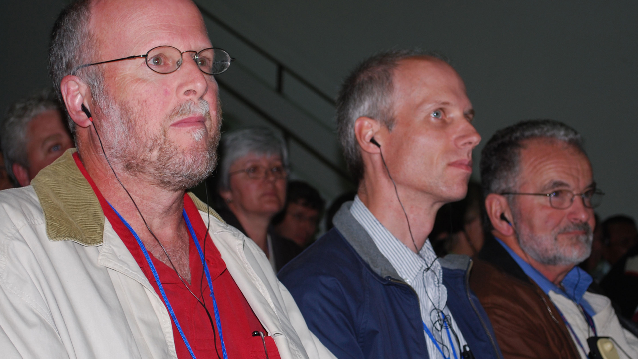Past Editors: At the Mennonite World Conference assembly at Asuncion, Paraguay, in 2009, three editors whose publications preceded Anabaptist World listen to a speech. From left are Gordon Houser, editor of the GC version of The Mennonite, 1992-1998, and the MC USA version of The Mennonite, 2015-2020; Paul Schrag, editor of Mennonite World Review, 1996-2020; and J. Lorne Peachey, editor of Gospel Herald, 1990-1998, and the MC USA version of The Mennonite, 1998-2000 — Anabaptist World