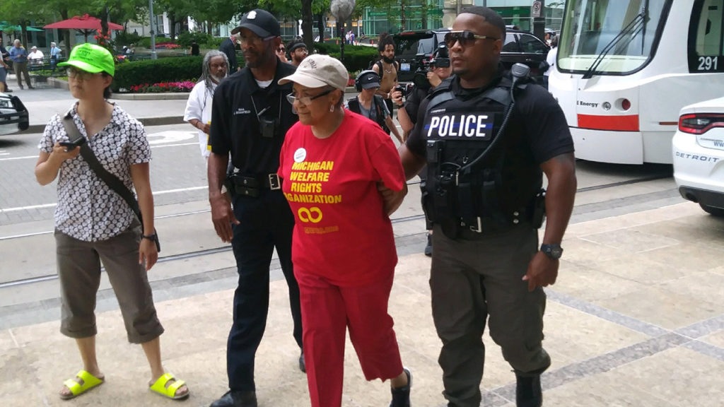 Marian Kramer is taken into custody by the Detroit Police Department after blocking the M-1 rail line with her walker on June 18, 2018. — Tommy Airey