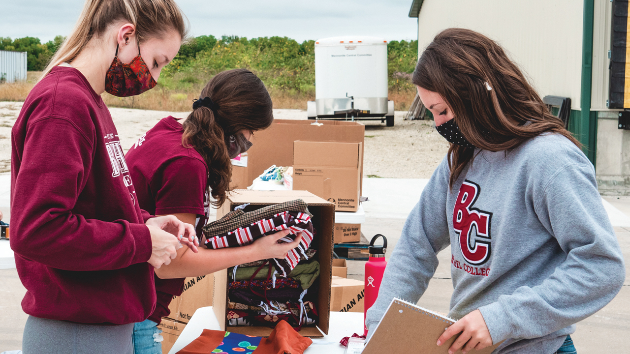 Bethel College students Julie Wilhite, Grace Lumpkins and Alexa Burch pack school kits at Mennonite Central Committee Central States on Sept. 23 during the college’s annual Service Day. — Taylor Brown/Bethel College
