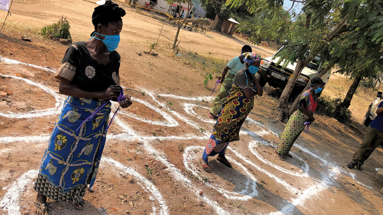 Women in the Democratic Republic of Congo wait for an MCC-supported food distribution, distanced to prevent transmission of coronavirus. — Jacob Sankara/Mennonite Central Committee
