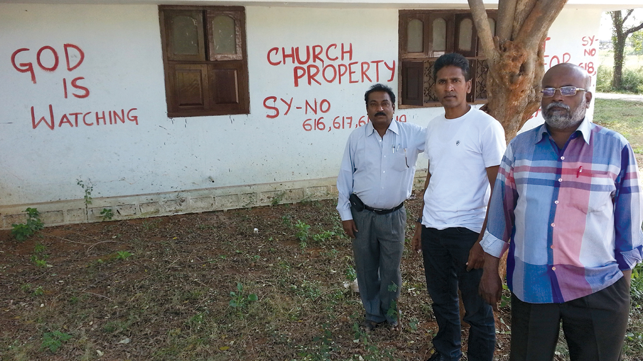 Members of the ad hoc committee for the General Council of MBCI, including Paul Gandham, center, painted warnings on the walls of Shamshabad Mission Compound and Bible College in 2013 after they say MBCI President P.B. Arnold made an illegal resolution for a financial transaction involving 25 of the property’s 34 acres. — Paul Gandham