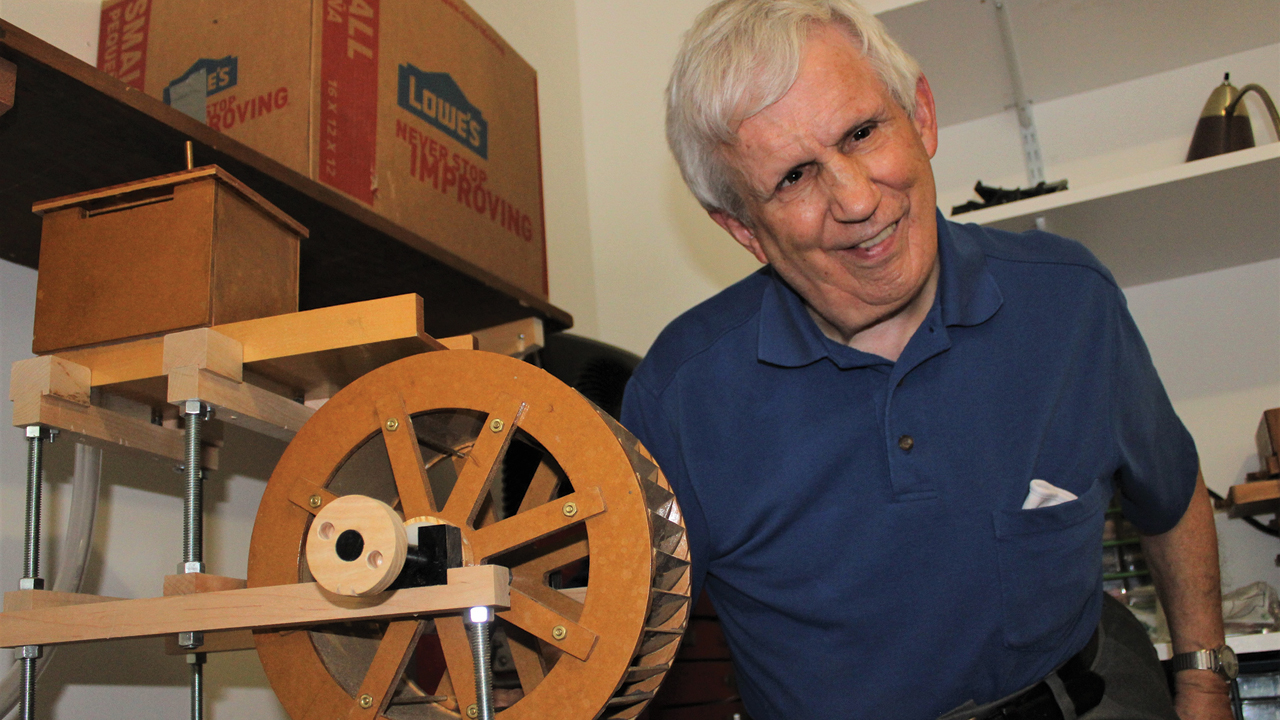 Dan Bowman displays his current project, a working model of a water-powered grist mill. — Jim Bishop