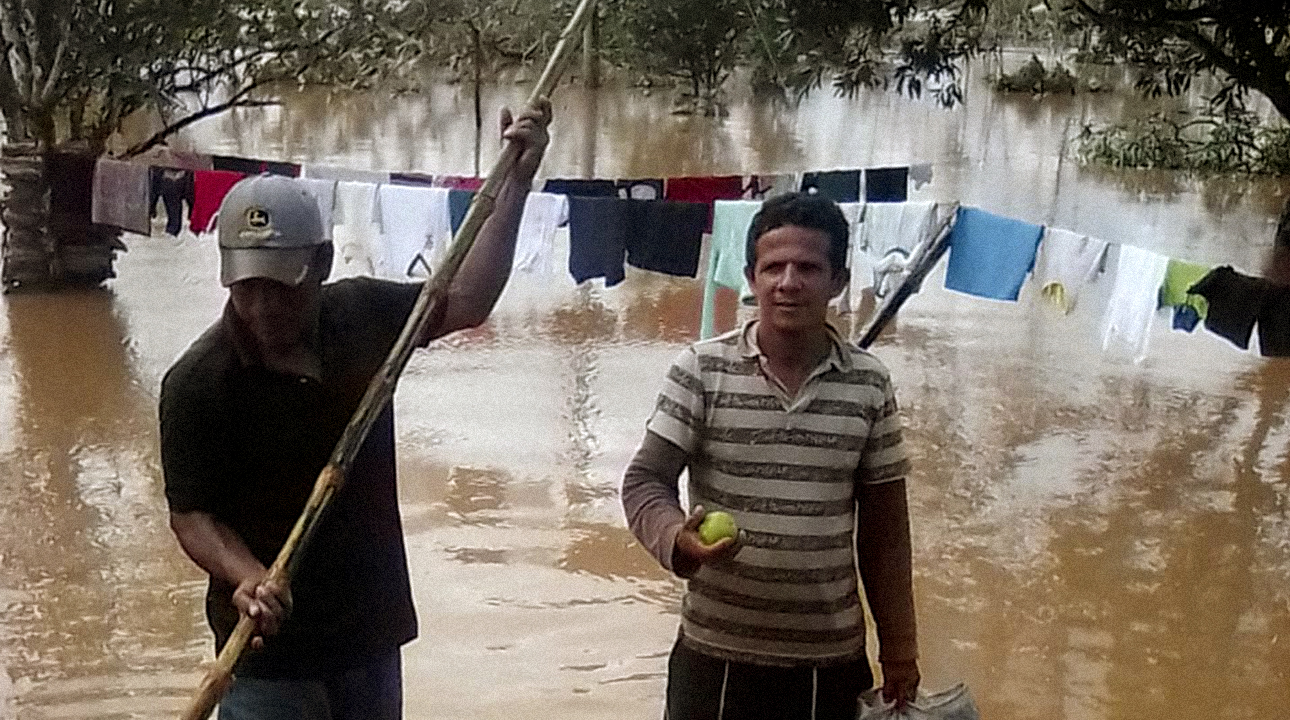 Ramón García, right, pastor of the Brethren in Christ church in Wasakín, Nicaragua, and Roger Stiven, an indigenous Mayagna community member, set off to assess the flood damage from Hurricane Iota in the northern region of Rosita. García is carrying a bag of oranges to distribute. For those in this disaster situation, it was not always possible or prioritized to follow COVID-19 precautions. — Ramón García
