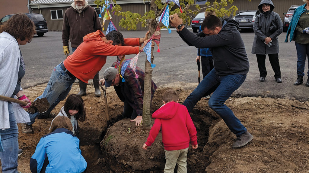 Children help plant one of more than 30 trees on May 12, 2019, during Assembly Mennonite Church’s tree-planting service in Goshen, Ind. — Nadia Shank/Assembly Mennonite Church