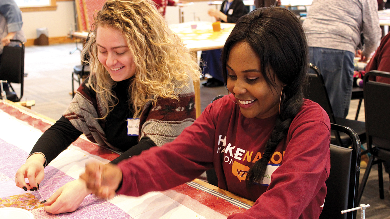 THIS WAS HOW WE PLANNED IT — Mennonite Central Committee’s Great Winter Warm-up in January was one of the few MCC centennial events held as scheduled in 2020. Pictured are International Volunteer Exchange Program participants Gabriela Furman of Brazil and Nsofwa Kaseketi of Zambia working on a comforter in Kidron, Ohio. — Jennifer Steiner/MCC