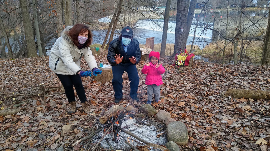 AMBS students Salomé Haldemann from France and Henok Mekonin from Ethiopia, with Henok’s daughter, warm up during the nativity walk. — Janeen Bertsche Johnson