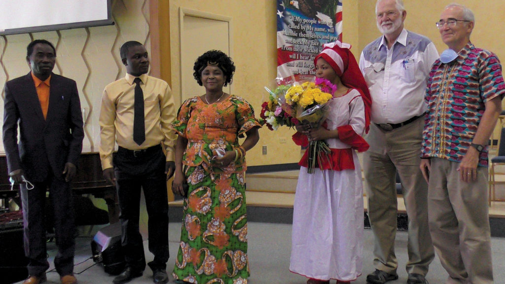 Amani Community Church celebrates the baptism of Adolphine Mateso, in white, on Aug. 2. Joining her are, from left, Kasukulu Bayoma, Masemo Wakibogo, Edouine Dino, Larry Buschman of Whitestone Mennonite Church and South Central Mennonite Conference regional ministry coach Clarence Rempel. After receiving a baptism name, Mateso is now known as Adolphine Tabitha. — Amani Community Church