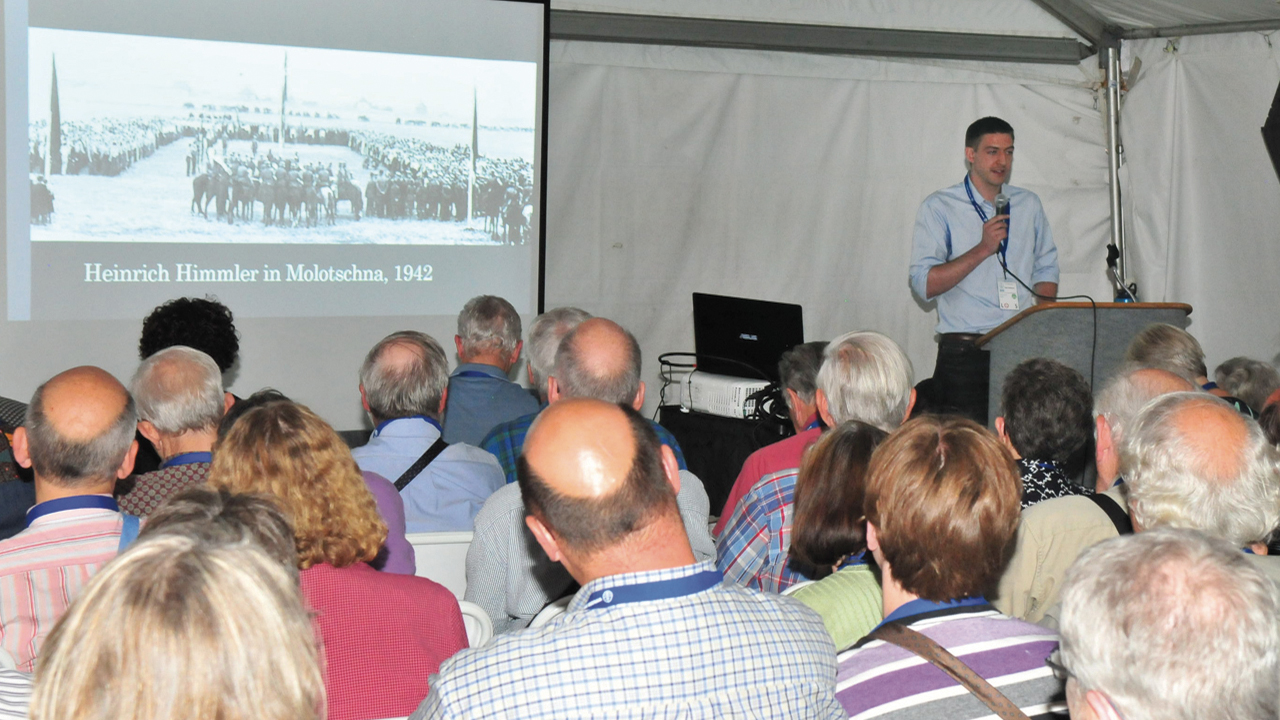 Historian Ben Goossen shows a photo, “Heinrich Himmler in Molotschna, 1942,” during his workshop, “From Aryanism to Multiculturalism: Mennonite Ethnicity and German Nationalism, 1871 to Today” at the 2015 Mennonite World Conference Assembly in Harrisburg, Pa. — Dale D. Gehman for Meetinghouse