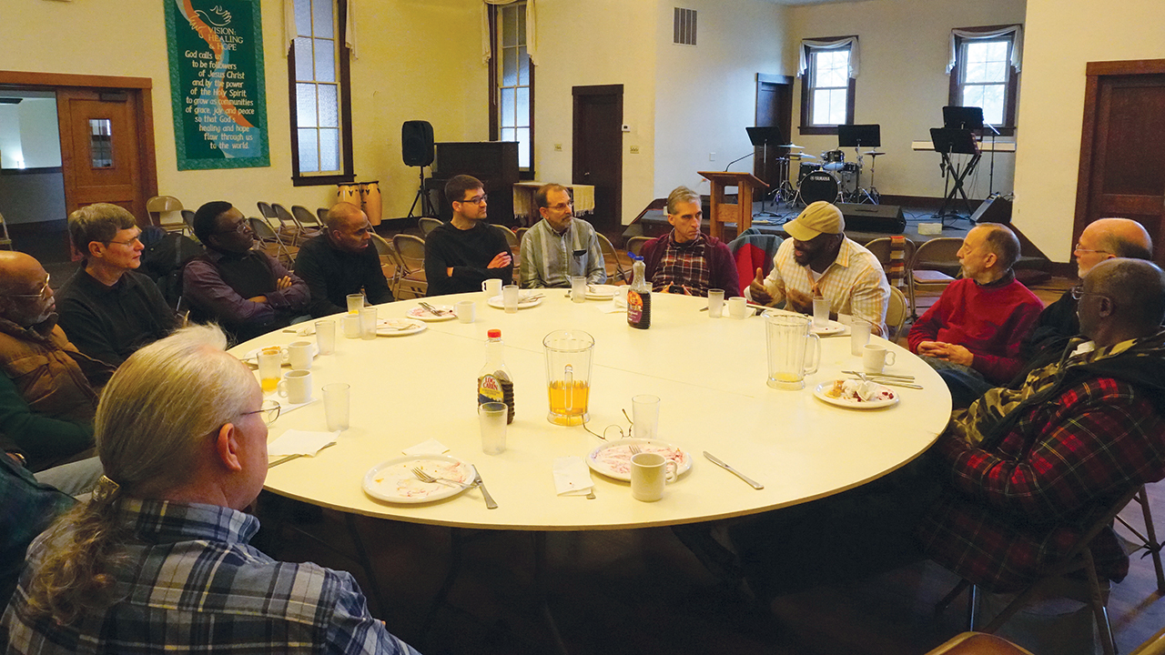 Juard Barnes, wearing a hat, shares his vision for a new ministry of reconciliation with Seeking the Beloved Community in 2018 at Fellowship of Hope. Herman Washington is at far left and Joe Sawatzky is center, in black sweater. — Keith Kingsley
