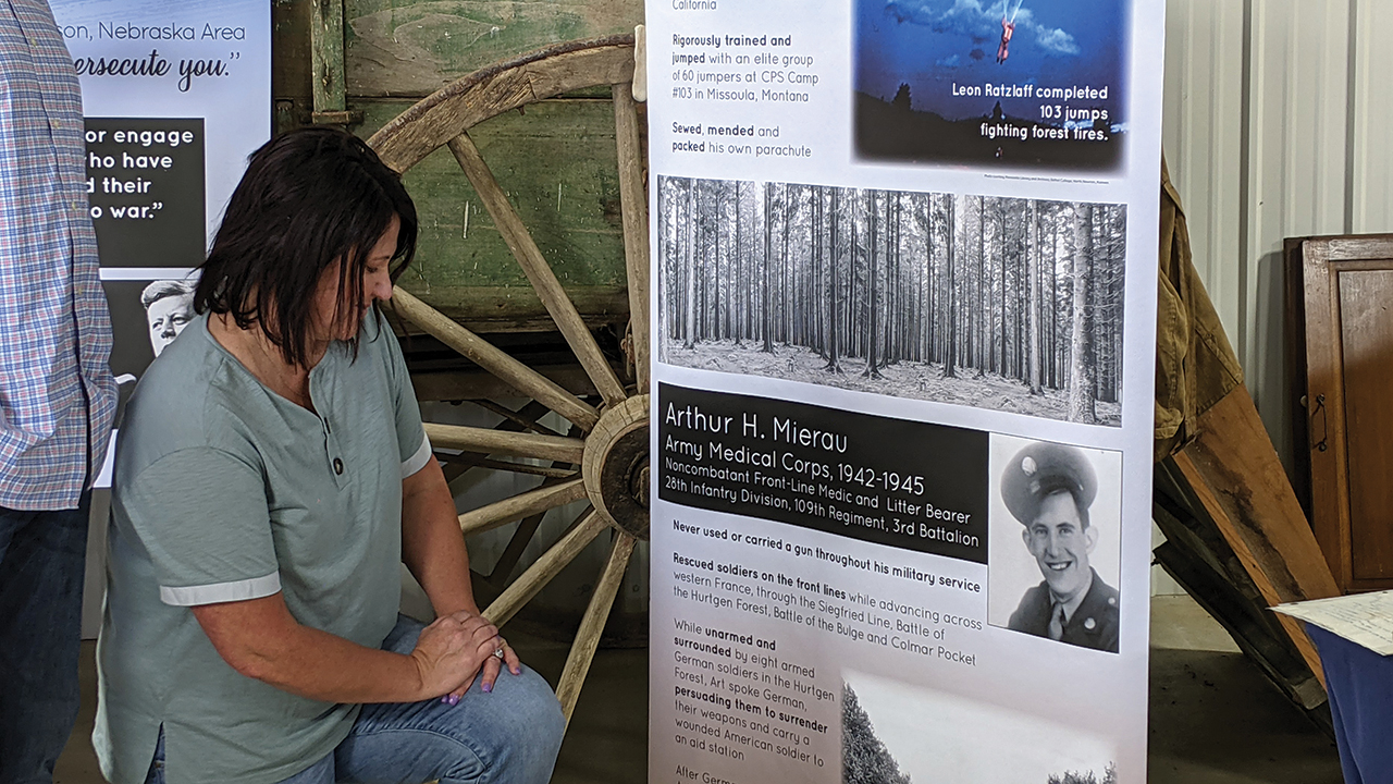 Dani Mierau Epp looks at a display about her grandfather Arthur Mierau, who received a Silver Star as a noncombatant medic and never touched a gun during his military service. On the front lines, he talked eight armed German soldiers into surrendering and carrying a wounded American soldier to his aid station. — Suzanne Freet Ratzlaff/Henderson Mennonite Heritage Museum and Park