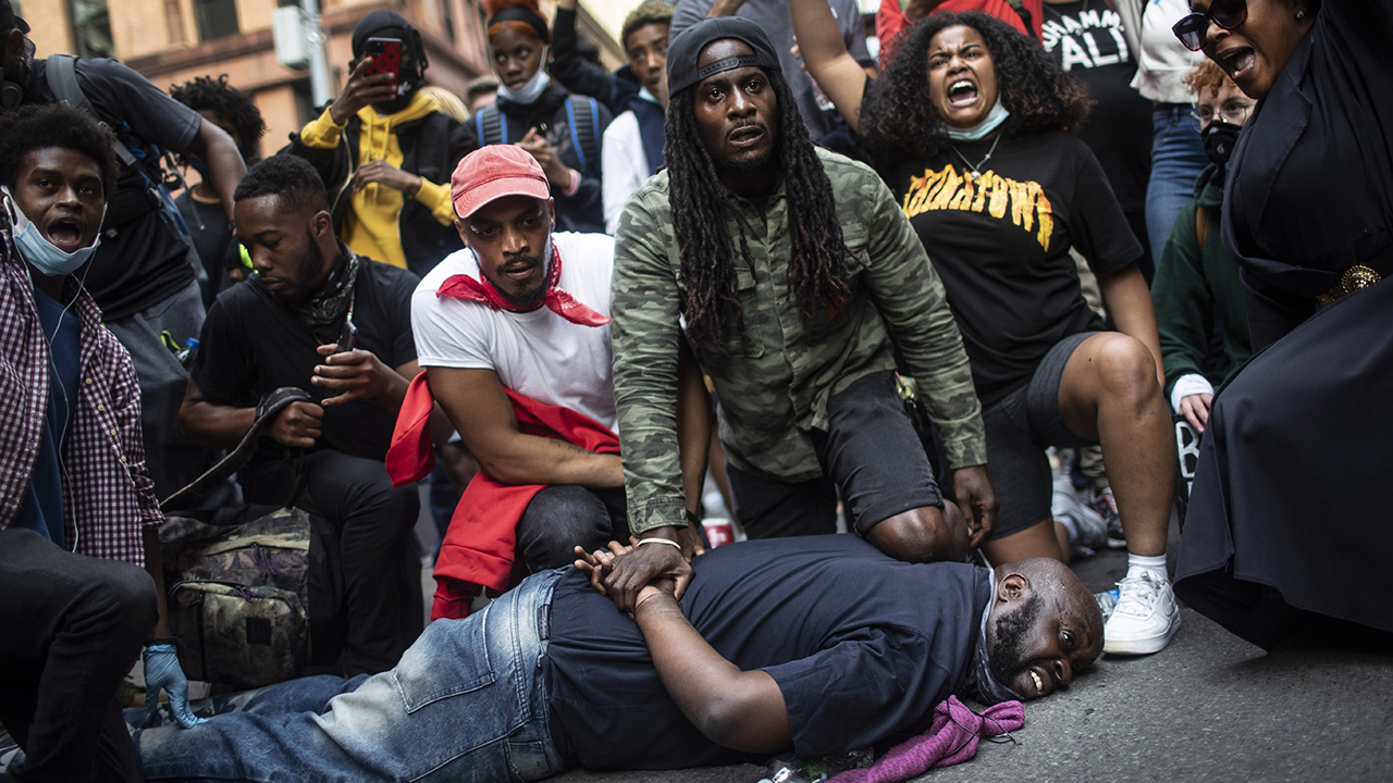 On June 2 in New York, protesters re-enact the scene where George Floyd was restrained by police. Floyd died after being restrained by Minneapolis police officers on May 25, 2020. — Associated Press