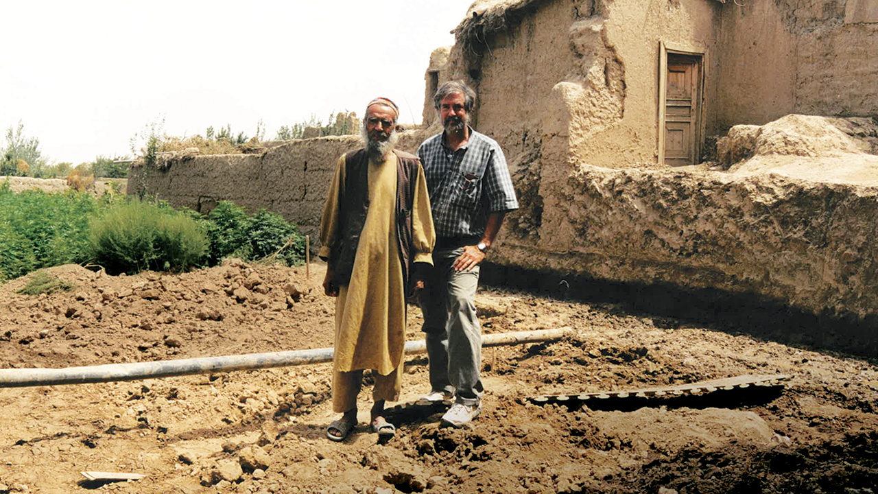 Abdul Hadi, pictured with Doug Hostetter in August 2002, returned to his home in Qala Kuja, Afghanistan, three years after it was destroyed in fighting between the Northern Alliance and the Taliban. Mennonite Central Committee and Church World Service helped him rebuild. — Doug Hostetter