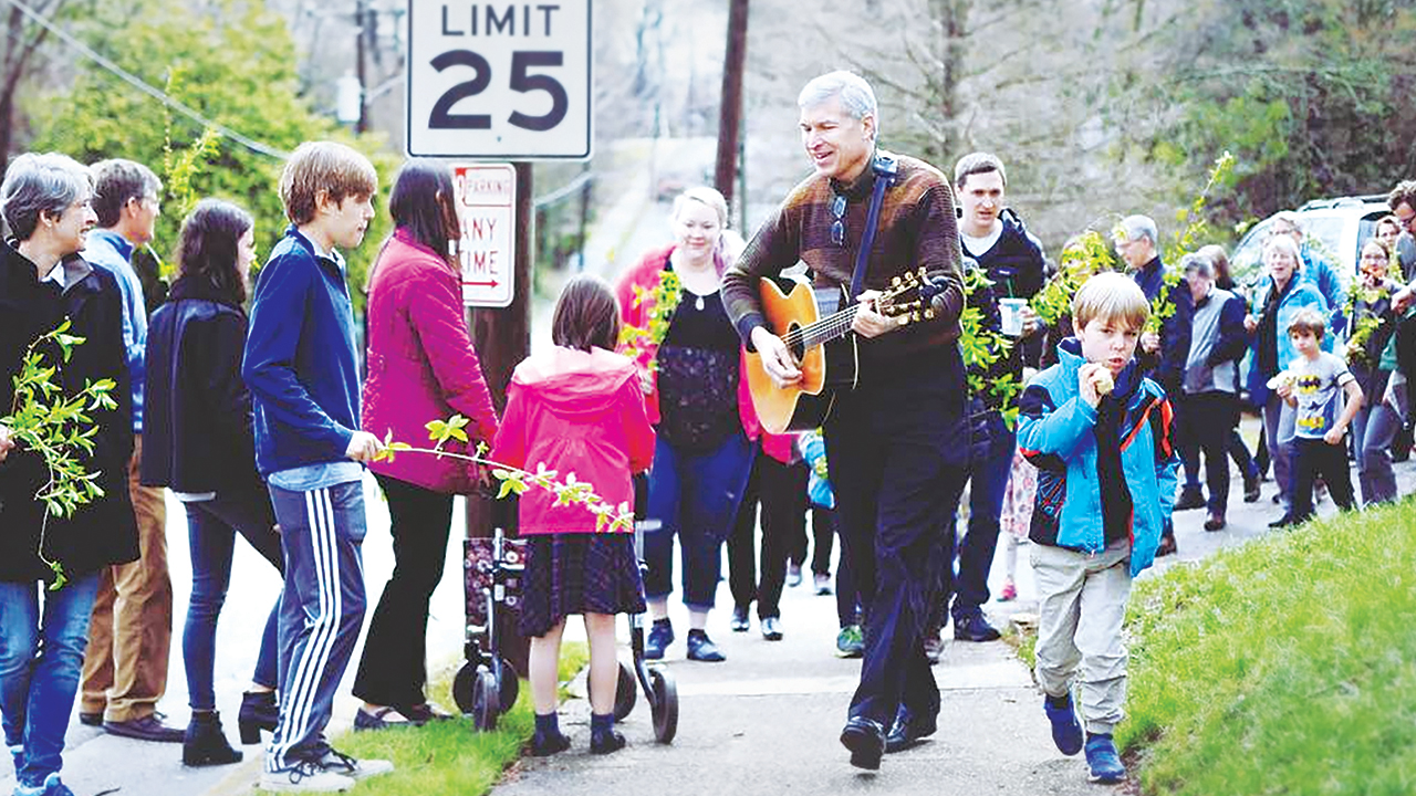 David Rohrer leads a Palm Sunday procession at Raleigh Mennonite Church in 2018. — Claire Unruh