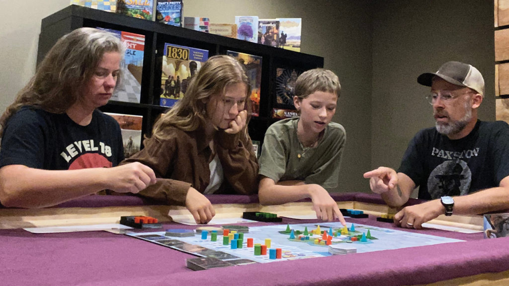 Kristin Green, Tona Ratigan Green, Siobhan Ratigan Green and John Ratigan play a board game in their Minneapolis home. — John Ratigan