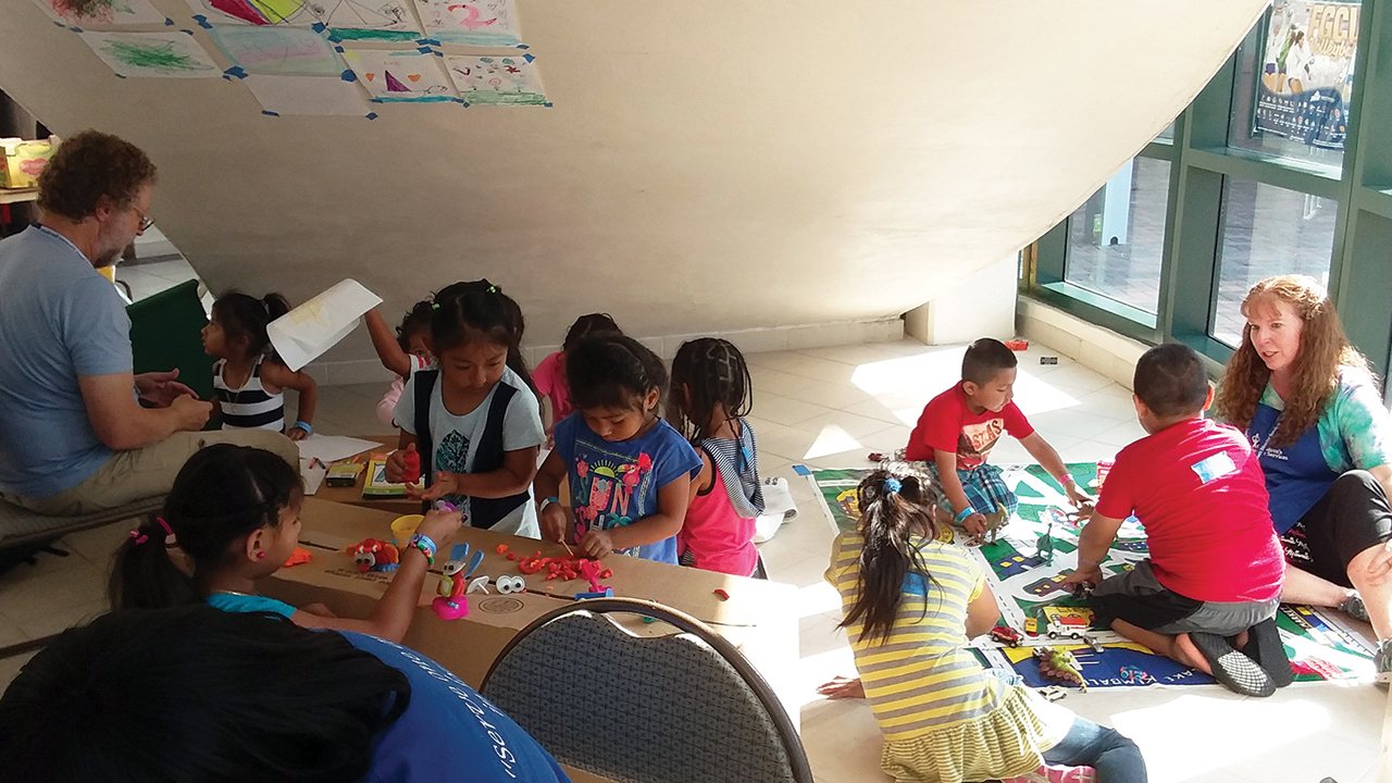 Children’s Disaster Services volunteers Tom and Linda Cooper work with children in a Hurricane Irma evacuation shelter in 2017 in Fort Myers, Fla. The facility was so full, the children’s play area in Alico Arena was under the stairs. — Children’s Disaster Services