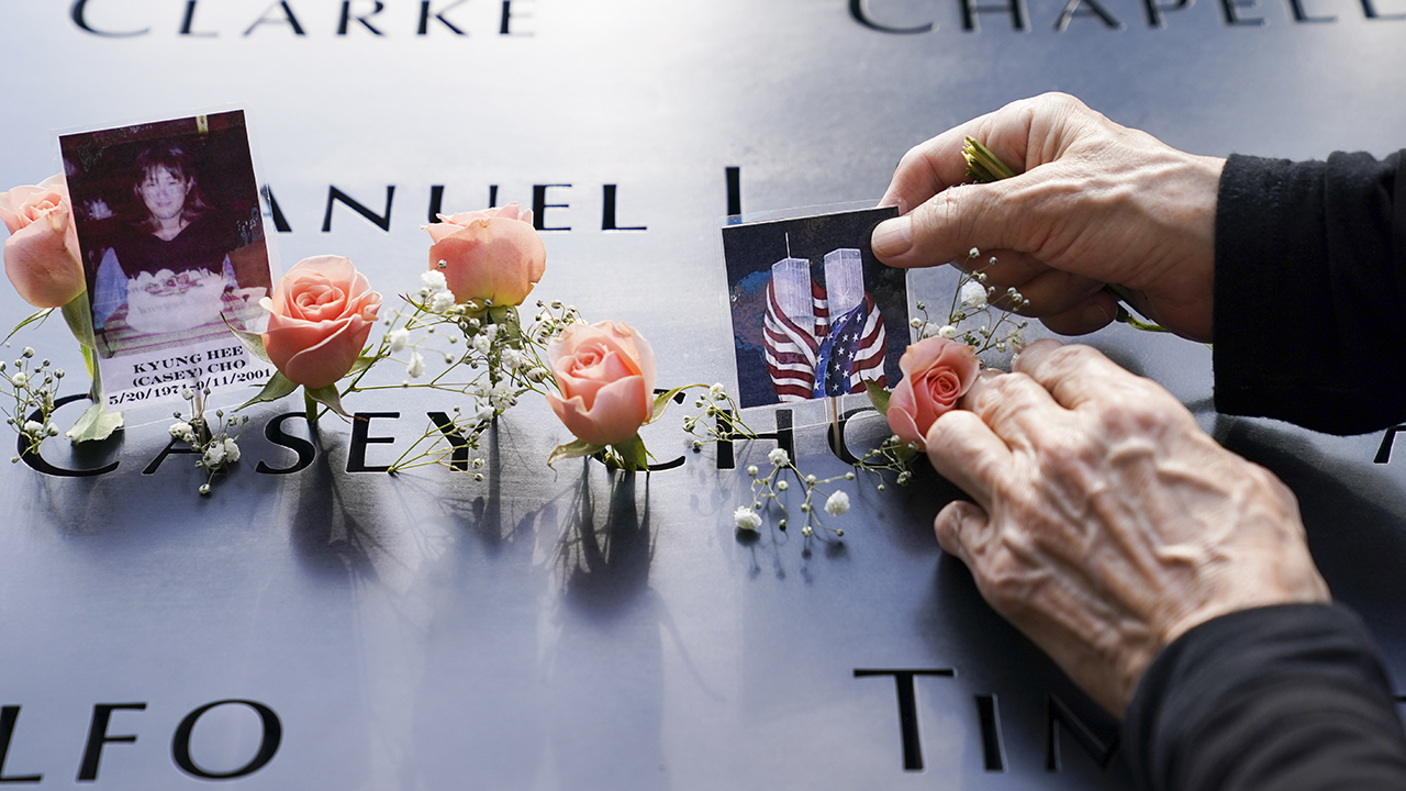 Mourners place flowers and pictures at the National September 11 Memorial and Museum on Sept. 11, 2020, in New York. — John Minchillo/AP