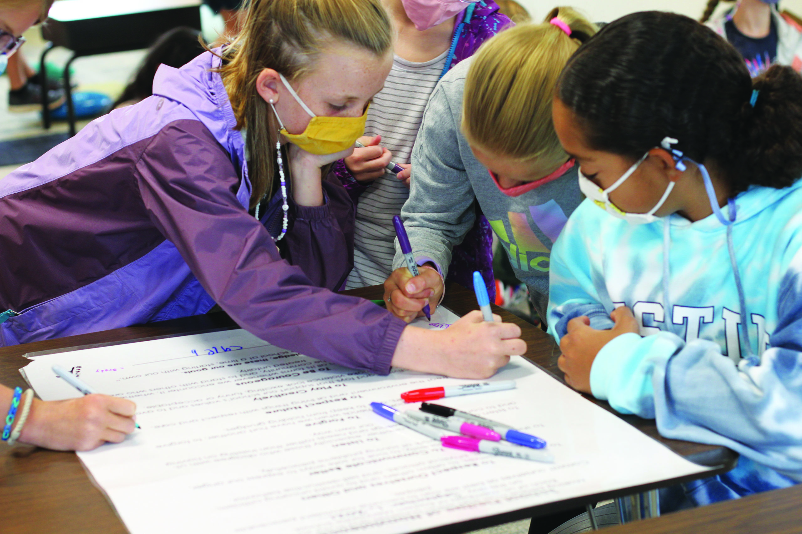 PLEDGING PEACE — Students at Eastern Mennonite Elementary School in Harrisonburg, Va., sign a peace pledge on Sept. 2. The pledge invites students to respect themselves and others, communicate better, listen, forgive, respect nature, play creatively and be courageous.
