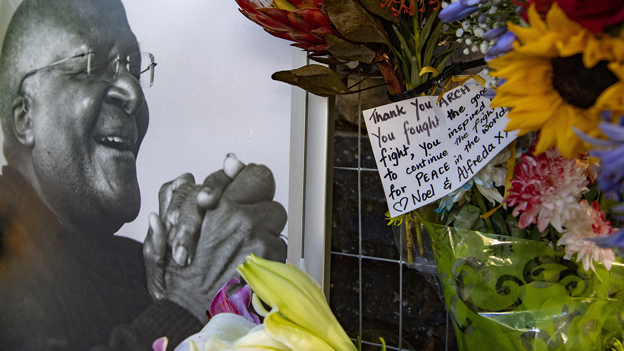 Flowers and a thank you note surround a portrait of former Anglican Archbishop Desmond Tutu outside St. George's Cathedral in Cape Town, South Africa, on Dec. 27. — Associated Press