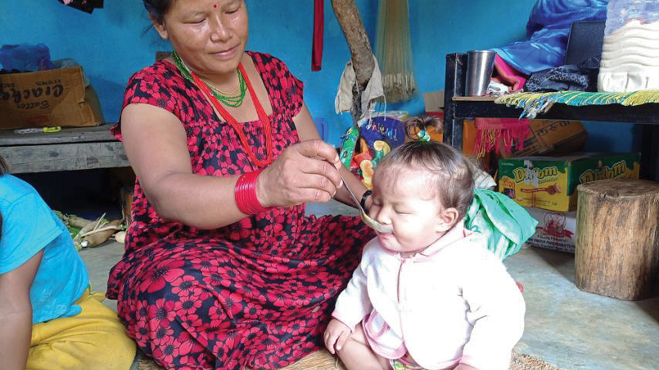 Sumitra Chepang feeds a spoonful of super porridge to her 10-month-old daughter, Promisa, in their home in the village of Syammaidada, Nepal. — Mennonite Central Committee
