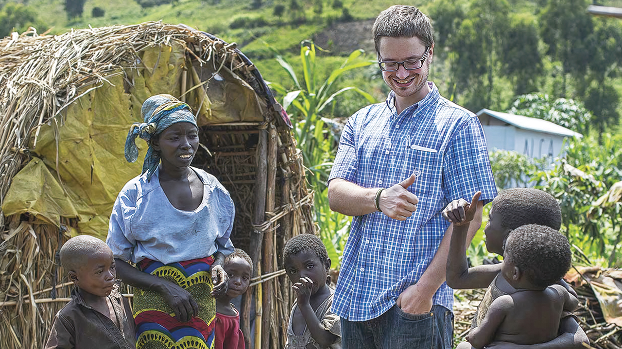 Michael Sharp visits with Elizabeth Namavu and children in Mubimbi Camp, home to displaced people in the Democratic Republic of Congo, in 2013. — Jana Ašenbrennerová/MCC