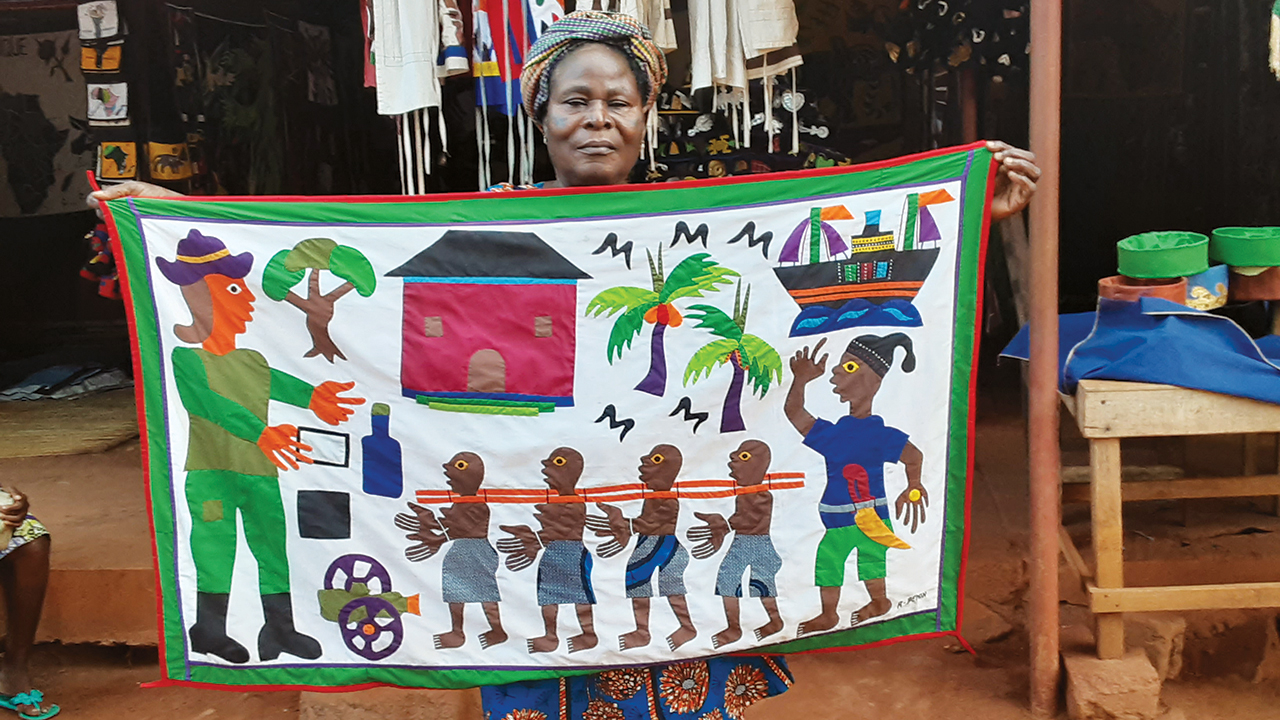 Cécile Yemadjé, an artisan in the Royal Palace of Abomey, Benin, holds her visual history of the transatlantic slave trade. — Rod Hollinger-Janzen/MMN