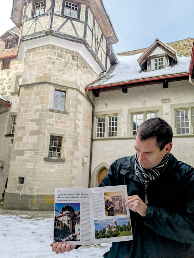 Tim Huber holds a copy of the Oct. 8 issue of Anabaptist World in the courtyard of Trachselwald Castle. The issue included a story about the opening of an exhibit about Anabaptism at the castle. — Heidi Huber