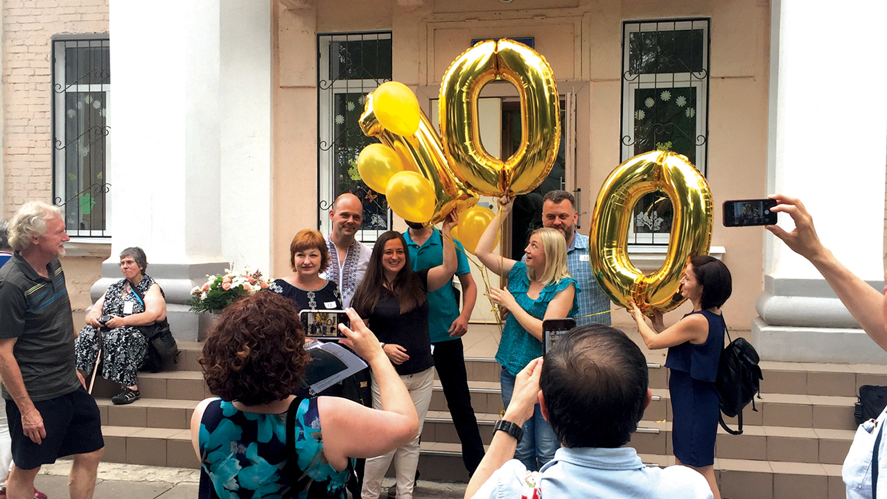 Mennonite Central Committee staff and partners raise 100th anniversary balloons after a worship service on June 23, 2019, in Khortitsa, Ukraine, at a “house of culture” where a Mennonite congregation met until 1935 — Paul Schrag/Mennonite World Review