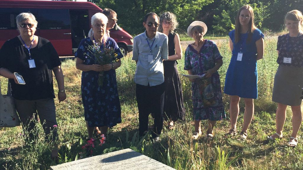 Visitors lay flowers at a memorial in Eichenfeld, Ukraine, where 82 Mennonites were killed by forces of the anarchist leader Nestor Makhno in 1919. — Paul Schrag/Mennonite World Review