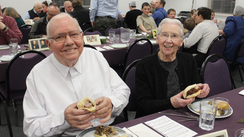 Robert and Twila Risser enjoy Berner sausage sandwiches on March 9 at Marion Mennonite Church in Chambersburg, Pa. The meal preceded a commemoration of an illegal Lenten meal of sausage that marked a symbolic beginning of the Swiss Reformation. — Elwood Yoder