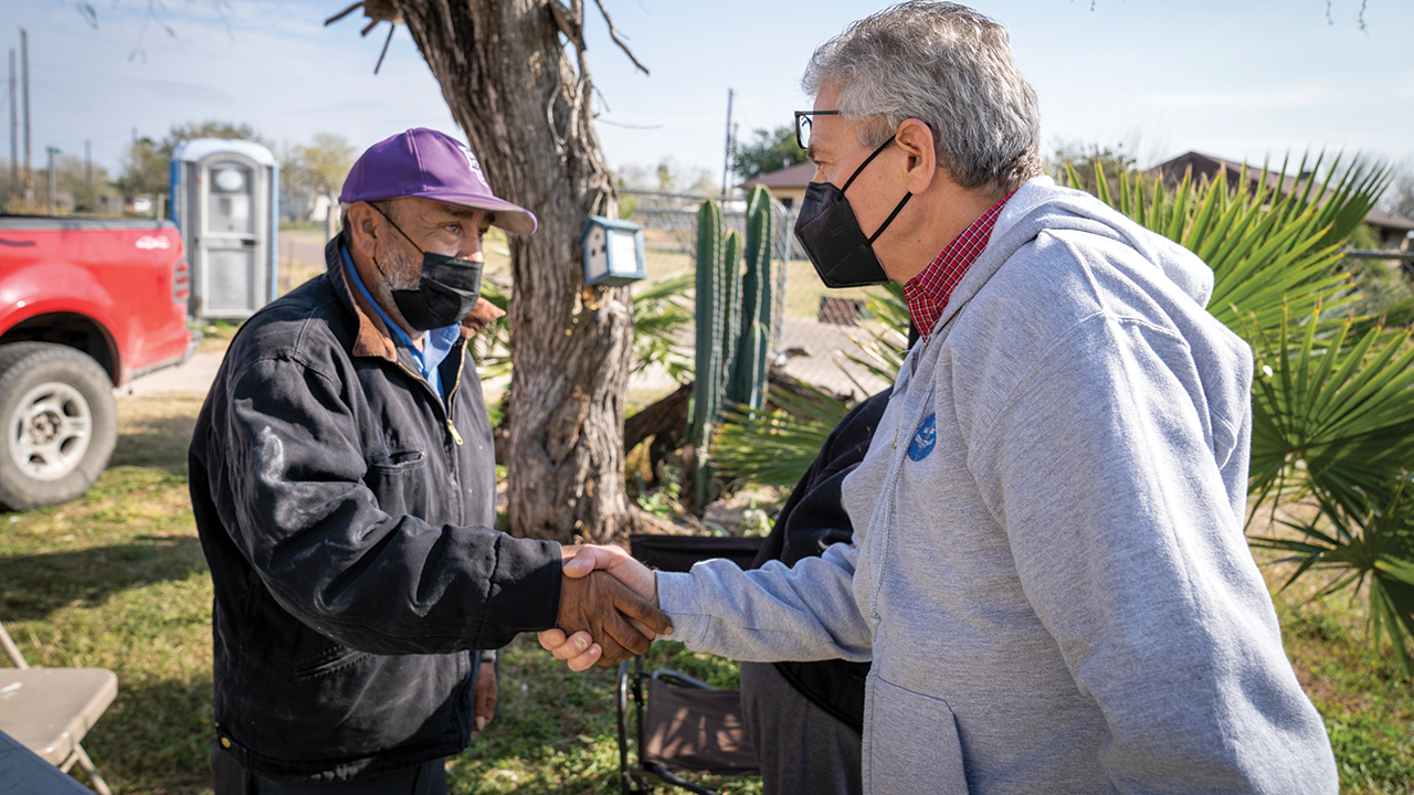 Homeowner Rafael, left, welcomes Mennonite Disaster Service executive director Kevin King in February in McAllen, Texas, where MDS volunteers are rebuilding homes after the 2018 flooding of the Rio Grande River. — Paul Hunt/MDS