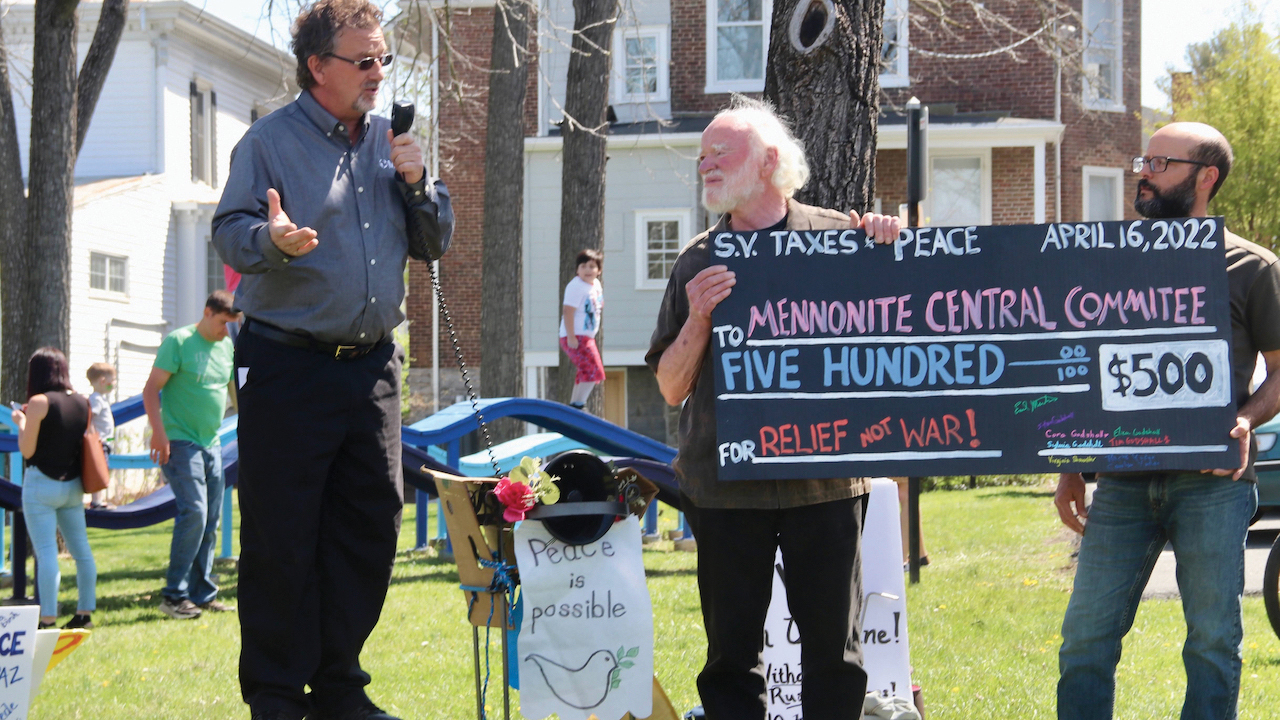 Mennonite Central Committee East Coast representative Luke Schrock Hurst, left, accepts a donation from Shenandoah Valley Taxes for Peace members Earl Martin, center, and Tim Godshall. — Tim Godshall