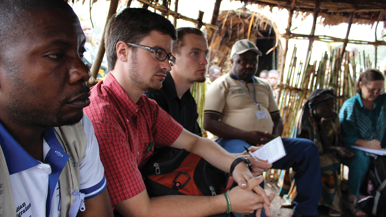 Michael J. Sharp, center, participates in a 2013 meeting at a camp for internally displaced people in the Democratic Republic of Congo. At left is Mitterrand Aoci Lwitela of the Church of Christ of Congo’s Ministry of Refugees and Emergencies, an MCC partner organization. At right is Patrick Maxwell of MCC and and Fidle Kyanza, director of Church of Christ of Congo's Ministry of Refugees and Emergencies, an MCC partner organization. — Tim Lind/MCC