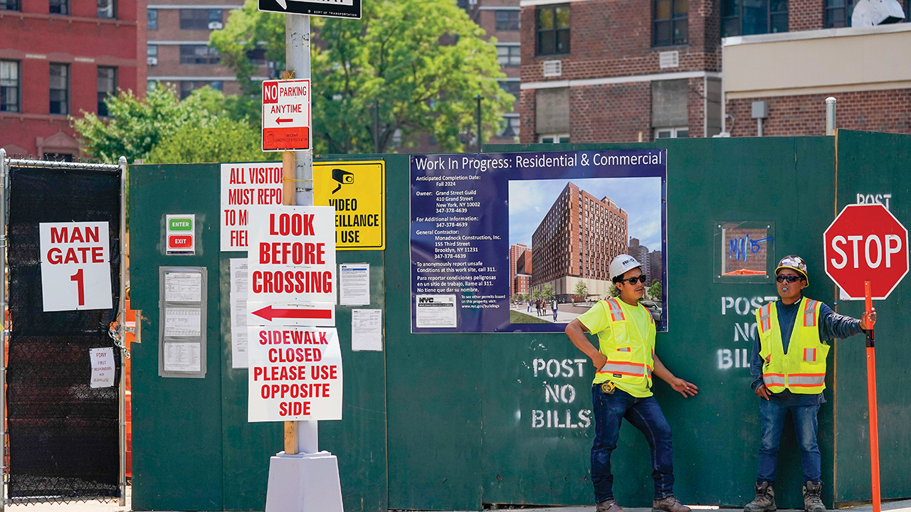 Construction workers help direct traffic outside a building under construction on the Lower East Side of Manhattan, N.Y., on Aug. 4. — Mary Altaffer/AP