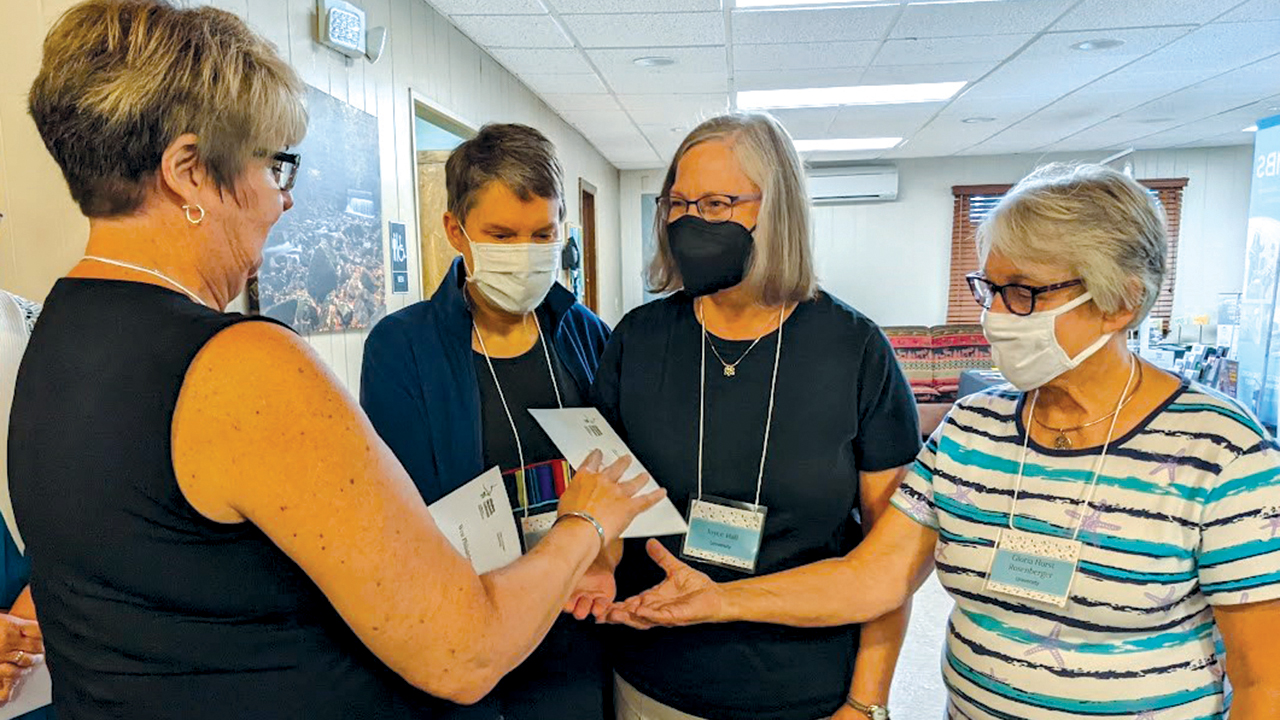 Allegheny Mennonite Conference treasurer Karin Miller, left, gives a distribution check to members of University Mennonite Church in State College, Pa.: Pastor Kate Heinzel, Joyce Hall and Gloria Rosenberger. — Carolyn Tice/AMC
