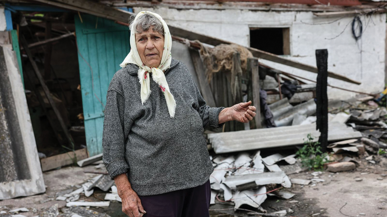 Nadiya O. surveys the wreckage of her home near Uman, Ukraine, destroyed by Russian bombing. She received canned meat and other relief items through an MCC partner, Uman Help Centre. Her last name and the name of her village are not provided for security reasons. — Uman Help Centre