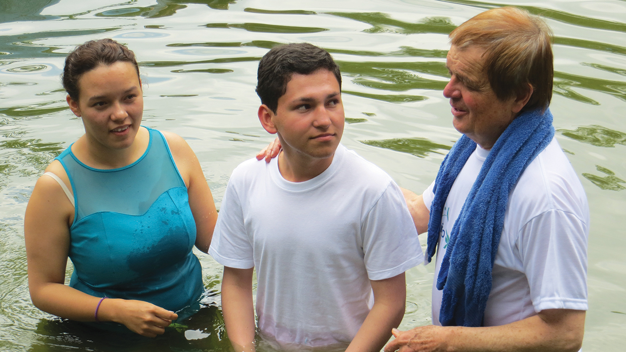 Peter Stucky, right, baptizes Juan Esteban Herrera Garzón in 2017 with the assistance of Lilia Aranguren. — Mennonite Mission Network