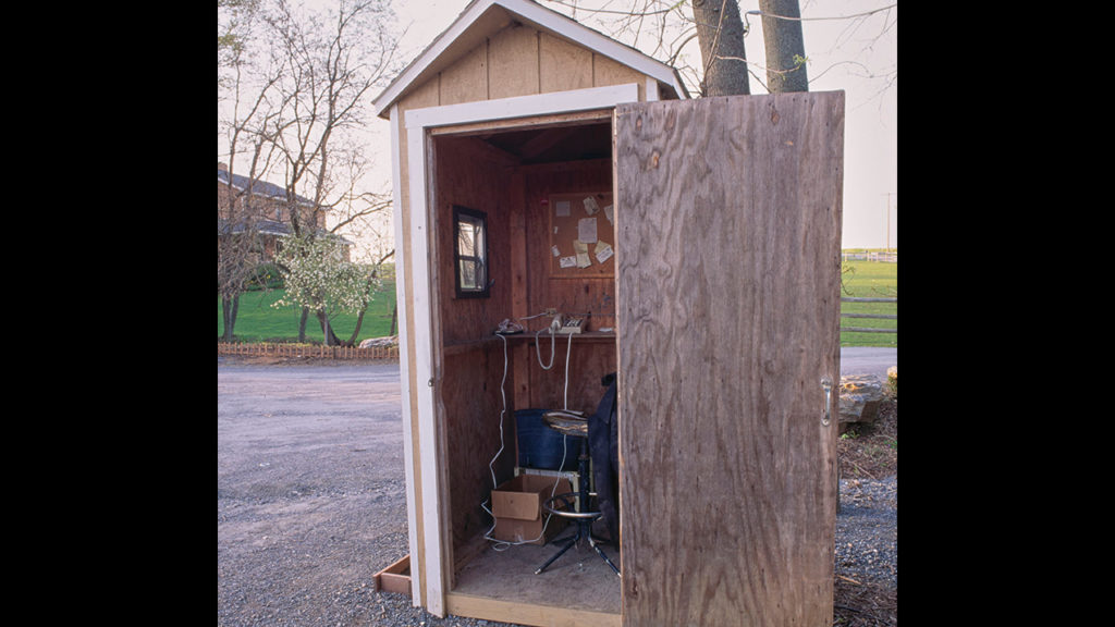 Like many Lancaster Amish, Leah has a plastic push-button phone installed in a drafty wooden shed outside her home. — Dennis L. Hughes Photographs of the Amish, Hess Archives, Elizabethtown College