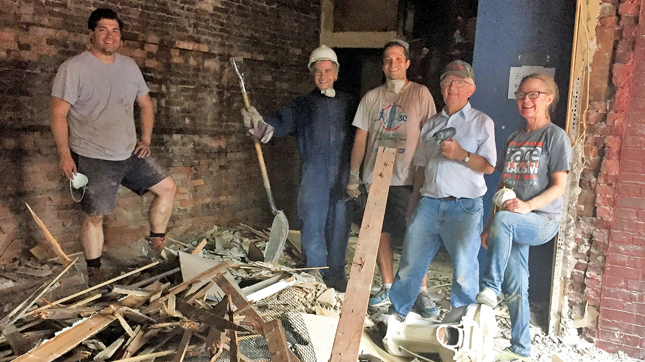 Ben Lesher, Will Maxey-Wert, Jonathan Stanley, Roland Yoder and Marlisa Yoder-Bontrager take a break from demolition of a bar in 2016 near East Chestnut Mennonite Church in Lancaster, Pa. — Chestnut Housing