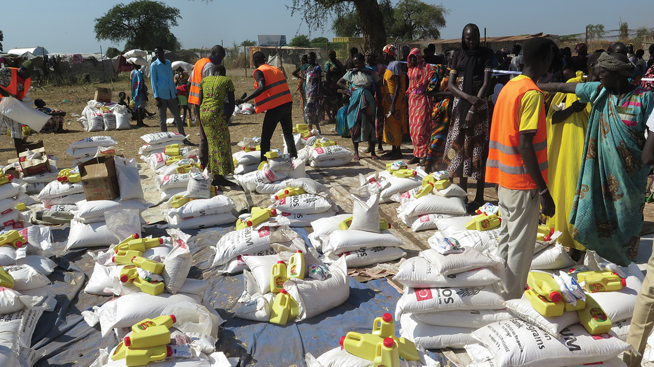 Residents of the Rubkona camp for internally displaced people pick up their food allotment with assistance from volunteers with an MCC partner, South Sudanese Development and Relief Agency. — Tadeo Santonino/MCC