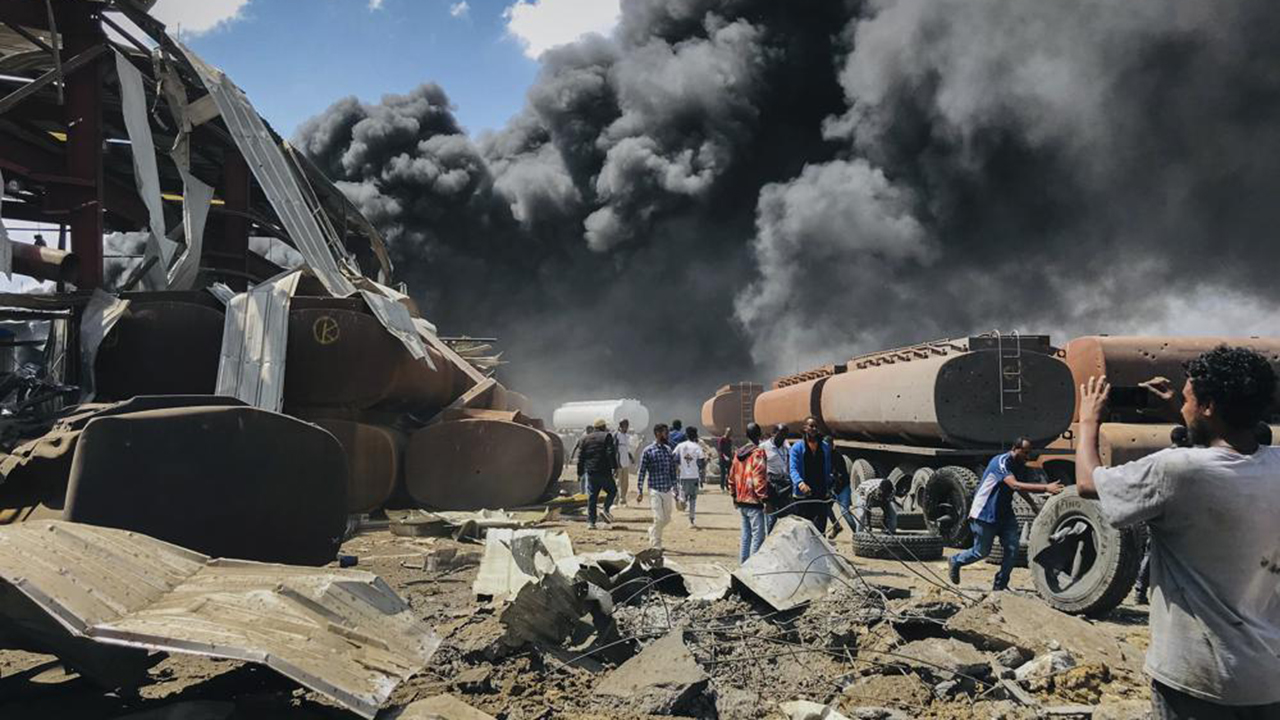 People are seen in front of clouds of black smoke from fires in the aftermath at the scene of an airstrike in Mekele, the capital of the Tigray region of northern Ethiopia, on Oct. 20, 2021. Ethiopia's warring sides formally agreed to a permanent cessation of hostilities in a two-year conflict, negotiators for the parties announced Nov. 2, 2022. — Associated Press
