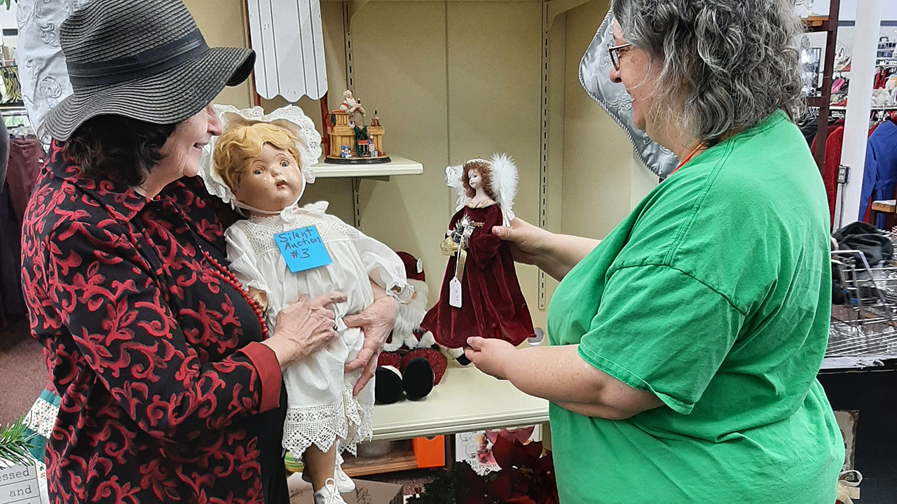 Hillsboro Et Cetera Shop assistant manager Kayla Rader, right, speaks with Peggy Goertzen after she won a vintage doll on silent auction. — Angela Becker/Hillsboro Et Cetera Shop