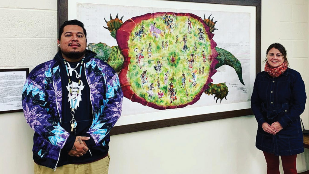 Artist Tokeya Waci U, left, and Ruth Harder, pastor of Rainbow Mennonite Church, with the painting that acknowledges the land originally belonged to Indigenous people. — Rainbow Mennonite Church