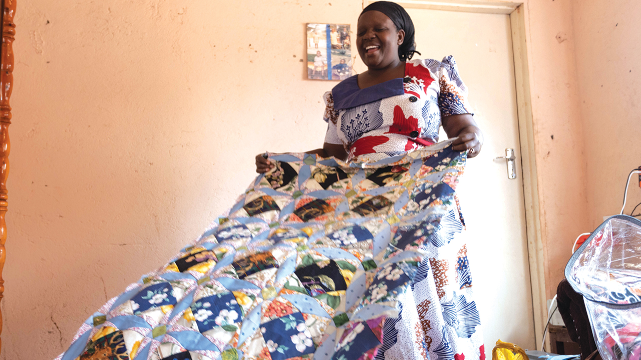 Addlight Mudombo shows a comforter she made from used clothing. Her husband, Elnathan Mboweni, designed the comforter top. — Meghan Mast/MCC