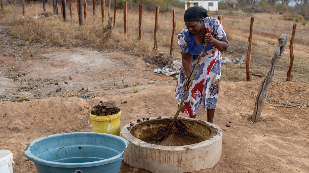 Addlight Mudombo mixes cow manure with water before feeding it to a biodigester where it turns into odor-free gas, which powers her gas stove in the kitchen. — Meghan Mast/MCC