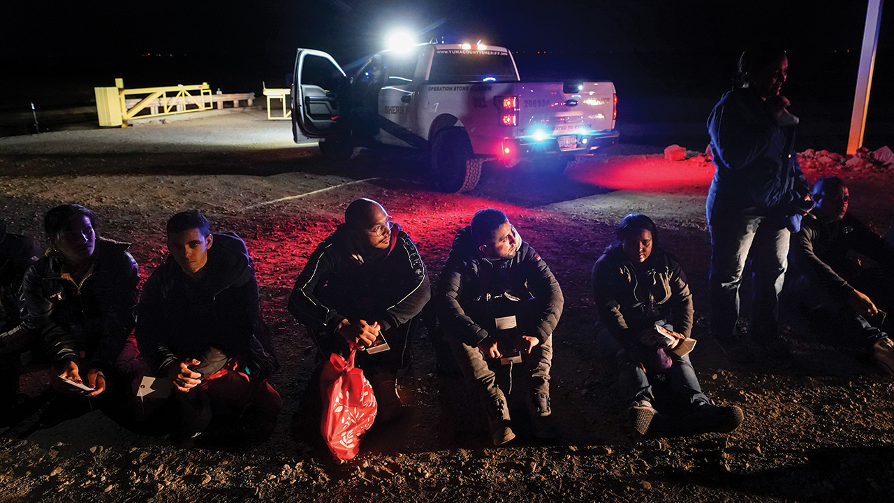 Migrants wait to be processed after crossing the border Jan. 6 near Yuma, Ariz. — Gregory Bull/AP