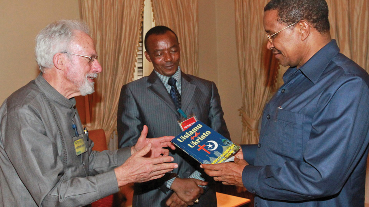 Bishop Amos Muhagachi, center, and David W. Shenk, left, present A Muslim and a Christian in Dialogue in Swahili to Jikaya Kikwete, then President of Tanzania, who requested 200 copies. — Eastern Mennonite Missions