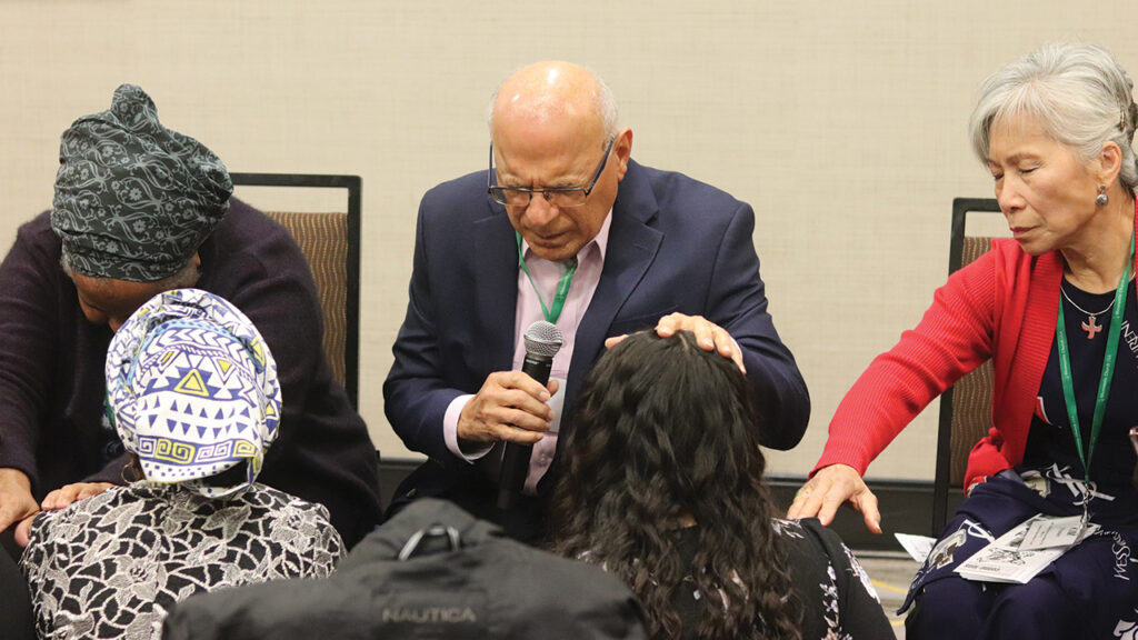 Wilma Bailey, Marco Güete and Kim Vu Friesen bless young adults at the Hope for the Future conference. — Lynn Hur/MC USA